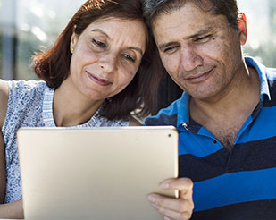 Couple sitting together and looking at a tablet