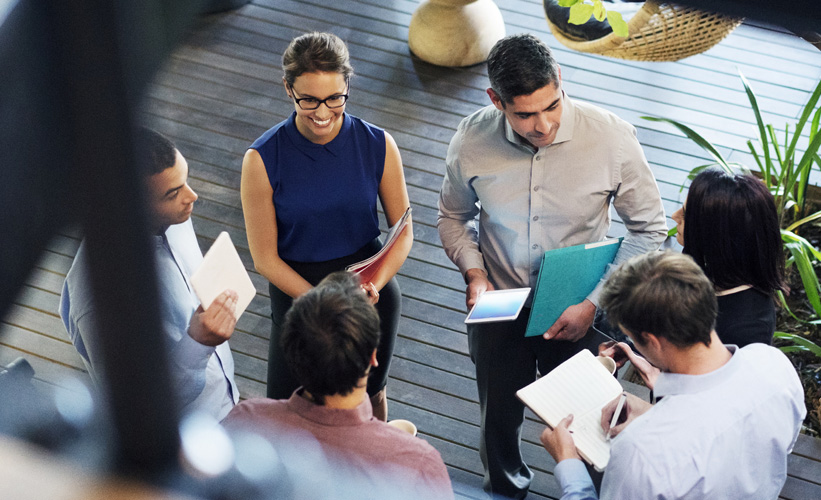 Group of people standing in circle talking to each other