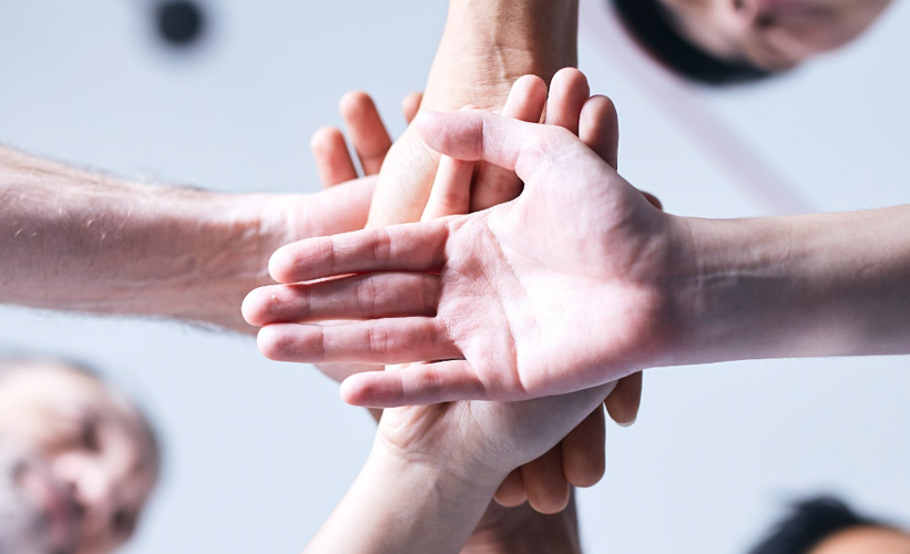 Group of people with their hands on top of each other