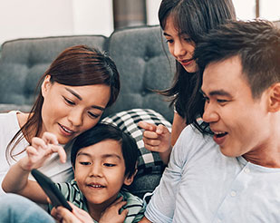 Family sitting together and having fun with a mobile phone