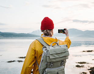 Man taking a picture of scenic mountain view