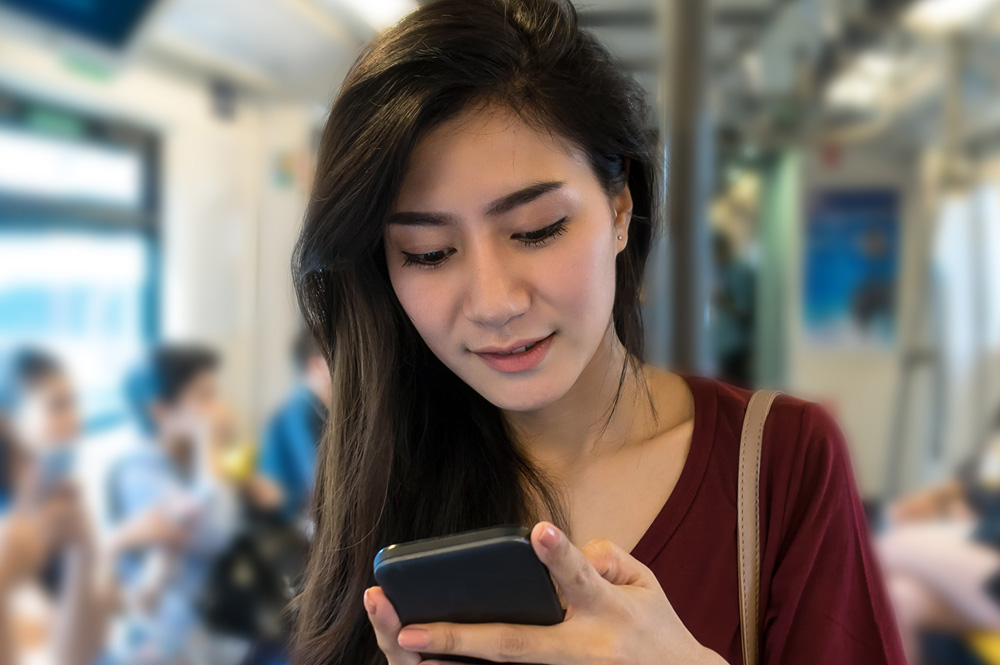 Woman browsing on phone on the subway