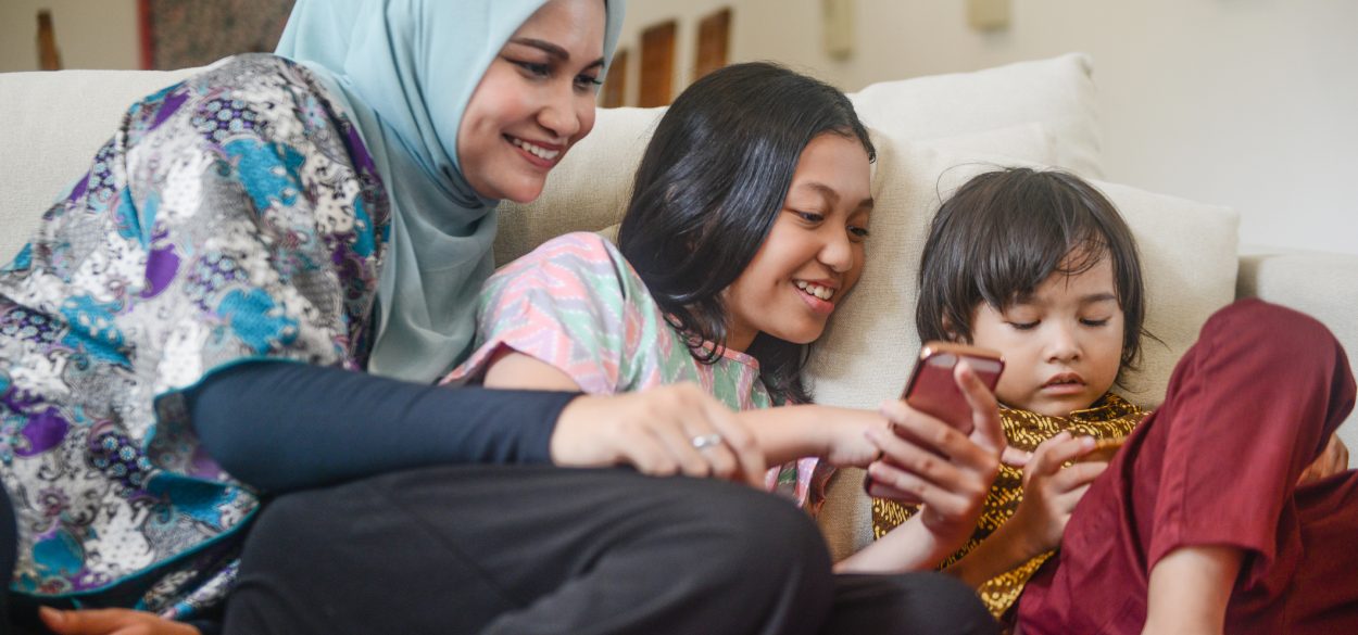 Woman sitting together with her children that's on their phones