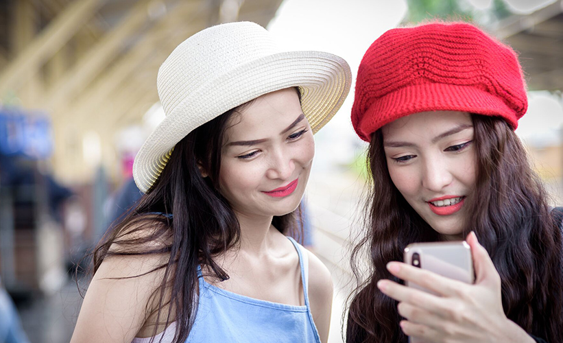 Two asian women looking at a phone