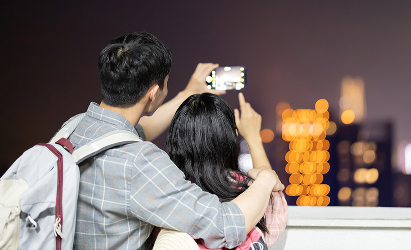 Couple taking a photo of a city skyline