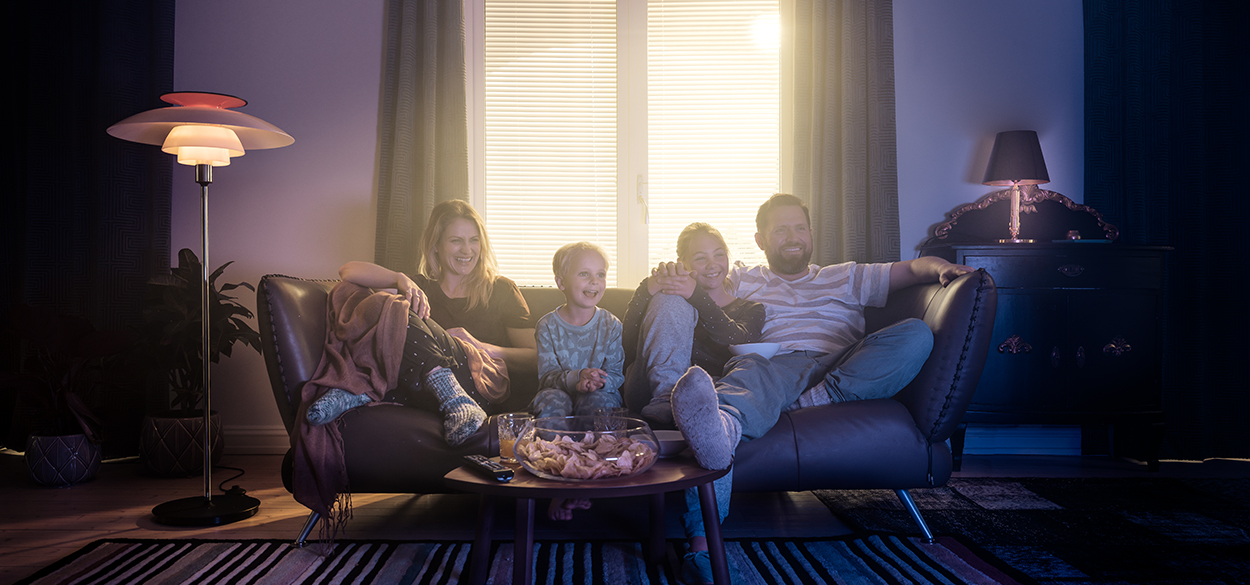 Family sitting on the couch watching TV