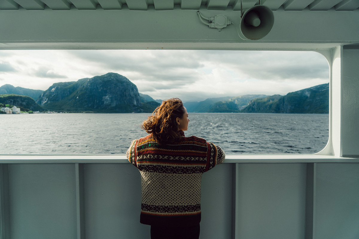 Kvinne på båt ser på fjord med fjell, med teksten "Telenors 3. kvartal 2026"