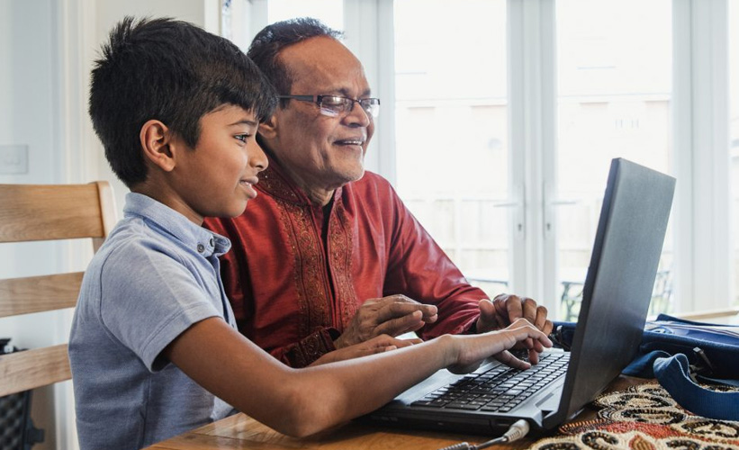 Boy and father looking at laptop together
