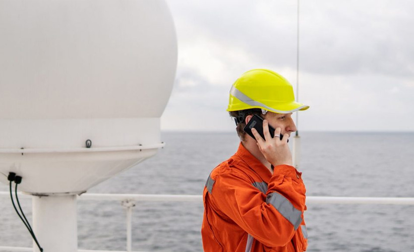 Marine Deck Officer on a ship speaking on the mobile phone.