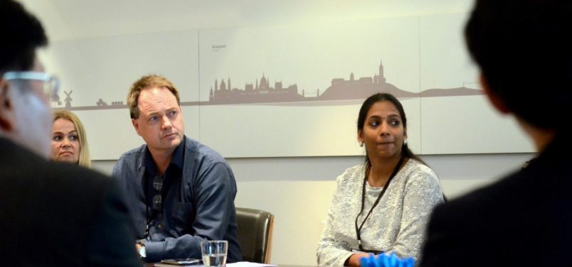 Group of people, including Papitha Sekar, watching a presentation