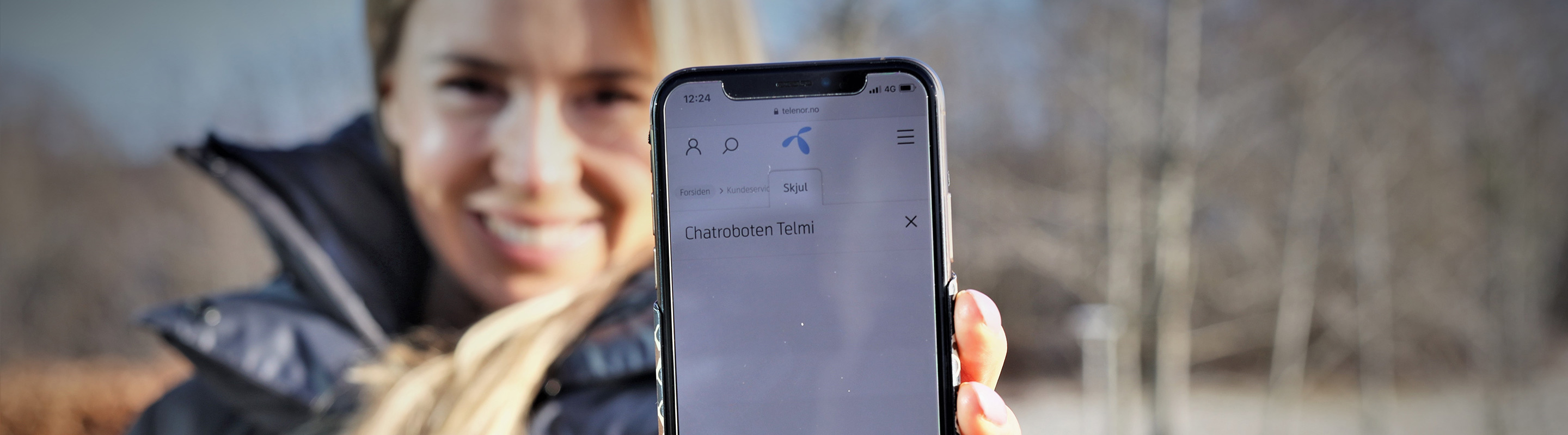 Woman presenting the Telmi chatbot on her smart phone