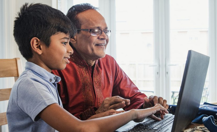 Boy and father looking at a laptop