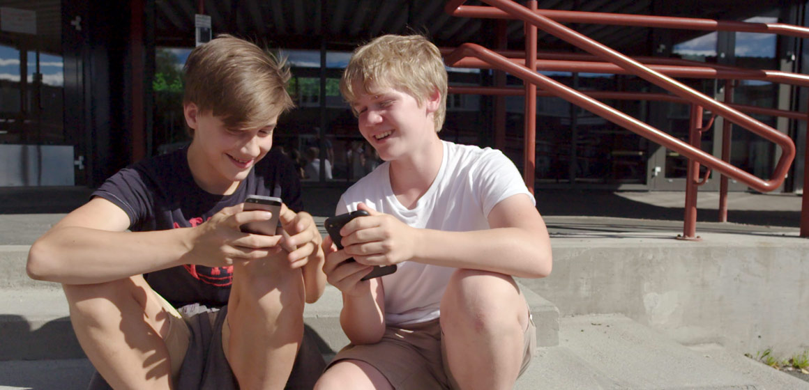 Two boys looking at a smart phone
