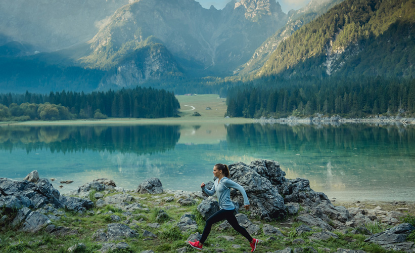 Woman running by a lake in the mountains
