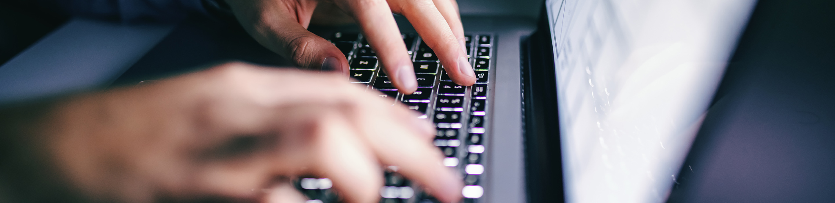 Close-up of a person typing on a computer keyboard