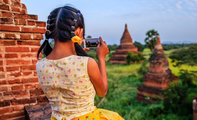 Child taking a photo of a landscape in Myanmar